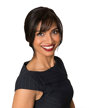 A woman with dark hair and red lipstick smiles, wearing a dark, sleeveless, pinstriped dress against a white background, embodying the confidence you need when navigating auto financing.